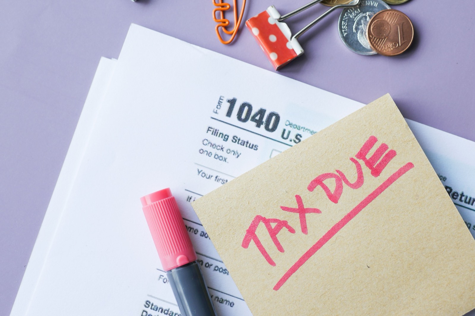 A Form 1040 with a note that reads TAX DUE and a pen