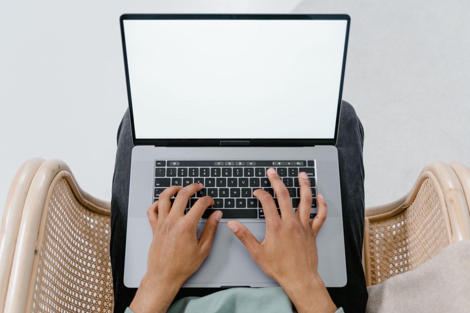 Manos escribiendo en una computadora portátil sobre una mesa de madera