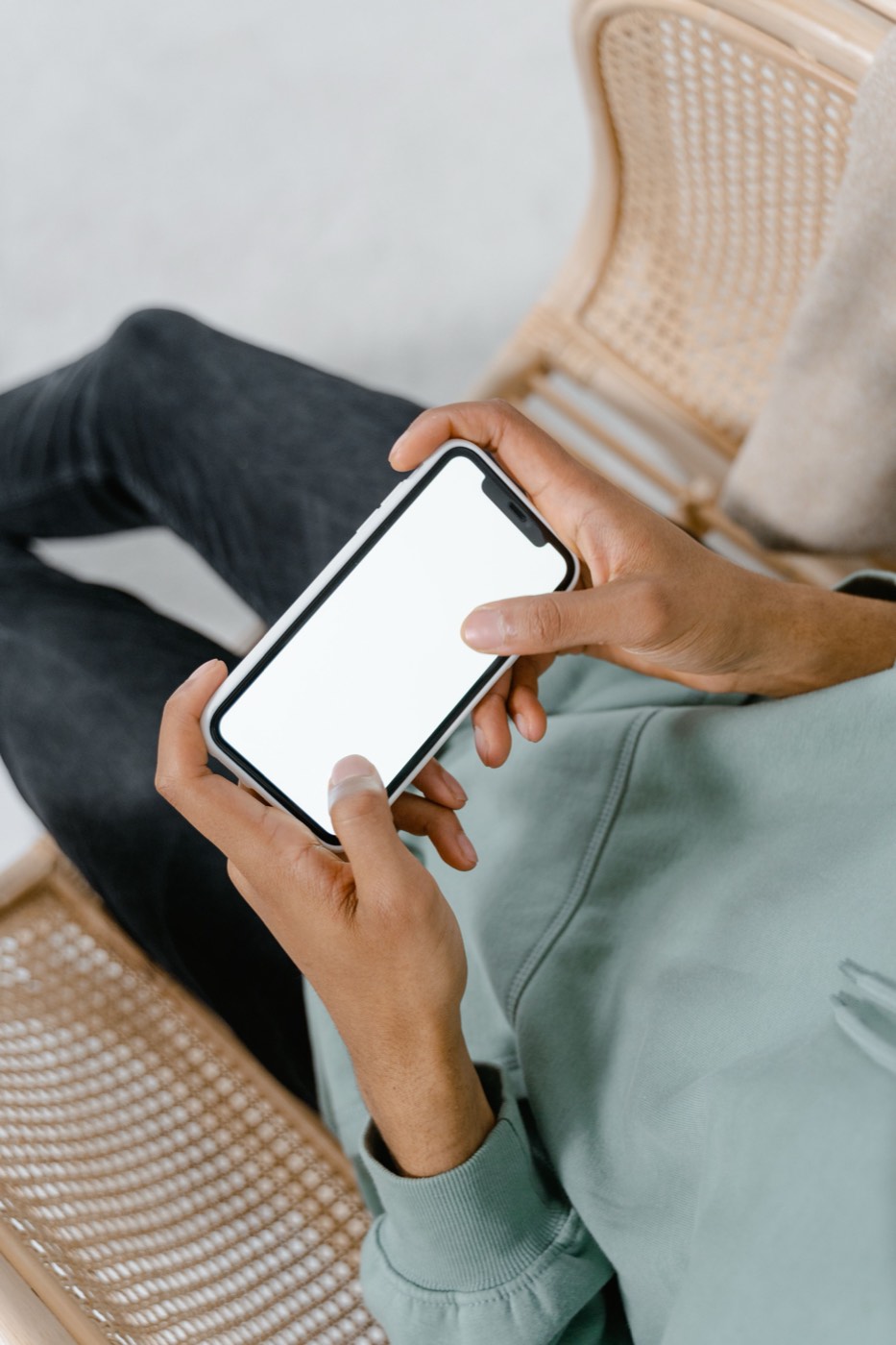 Persona sosteniendo un teléfono inteligente con ambas manos
